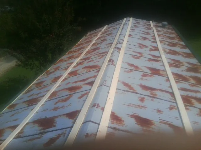 Rusted metal roof panels with new wood purlins before replacement — Storm Damage Roof Repair in Luverne by Roofing Brothers